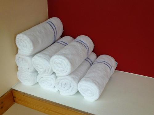 a pile of rolled towels sitting on a shelf at The Norfolk Lodge Hotel in Saint Helier Jersey
