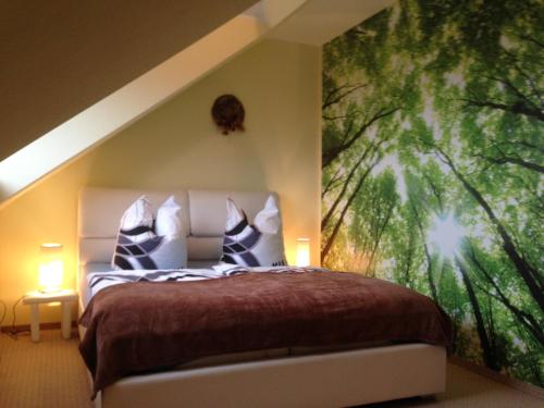 ein Schlafzimmer mit einem Bett mit einem großen Gemälde an der Wand in der Unterkunft Ferienwohnung Am Eichenberg in Blankenburg