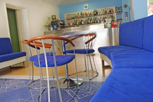 a bar with two chairs and a couch in a room at Hotel Metron in Cesenatico