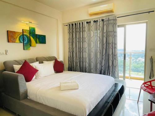 a bedroom with a bed with red pillows and a window at Atrium - ICONIC APARTMENT in Sri Jayewardenepura Kotte