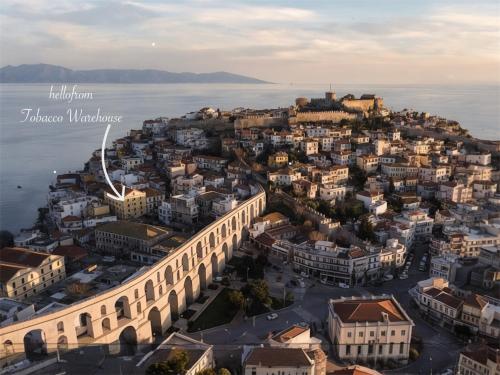 an aerial view of a city next to the water at hellofrom Tobacco Warehouse in Kavála