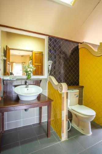 a bathroom with a sink and a toilet and a mirror at Pai Vieng Fah Resort in Pai