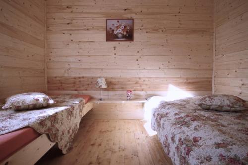 a bedroom with two beds in a wooden cabin at AIDA Domki Letniskowe - domki 5 min od MORZA - Plac Zabaw & ANIMACJE dla DZIECI, ROWERY gratis dla Gości in Rewal
