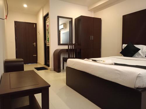 a hotel room with two beds and a table at Erica Hotel International in Perintalmanna