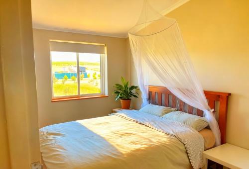 a bedroom with a bed with a mosquito net at The tiny homes at The Original Farm in Yass