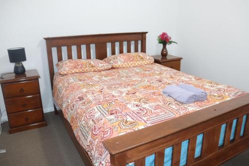 a bedroom with a bed with a wooden frame at The Sundown Stay in Dubbo