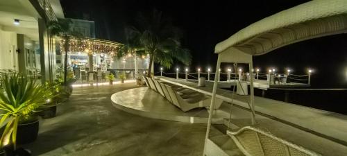 a building with a row of tables and chairs at night at Down South 118 Beach Resort in Oslob