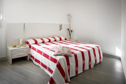a bed with a red and white striped blanket in a bedroom at Cala Palme Lampedusa in Lampedusa