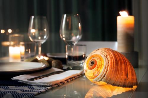 a snail sitting on a table with wine glasses at Cala Palme Lampedusa in Lampedusa