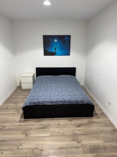 a bedroom with a bed and a wooden floor at Apartment City Center in Piteşti