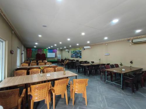a dining room with tables and chairs in a room at Rapti Resort in Jhawāni