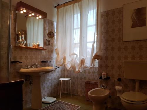 a bathroom with a sink and a toilet and a window at Se mi vuoi lasciare in Carcare