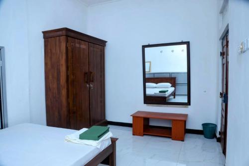 a bedroom with a mirror and a bed and a table at Jaffna Bungalow in Jaffna