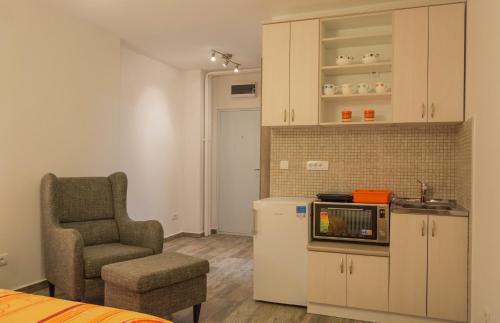 a living room with a chair and a kitchen at Apartment Hram in Belgrade