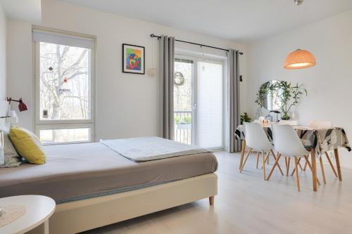 a bedroom with a bed and a table and chairs at QnQ studio apartment in Helsinki