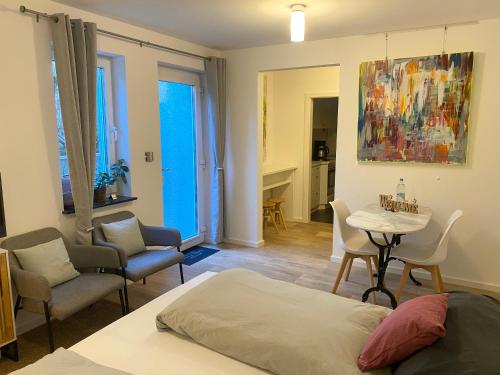 a bedroom with a bed and a table and chairs at Helle Souterrainwohnung mit Komfort in Munich