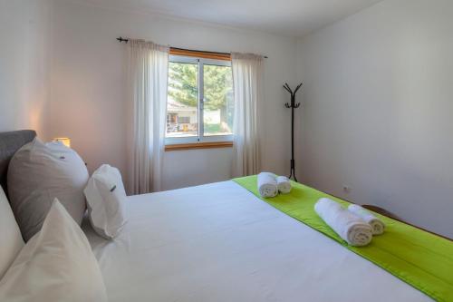 a bedroom with a large white bed with towels on it at Unforgettable Ocean Views-Spacious Seaside Villa in Mosteiros