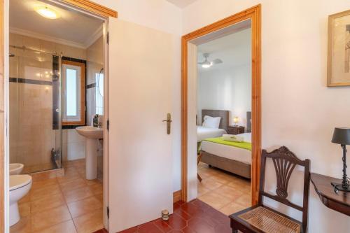 a room with a bathroom with a bed and a toilet at Unforgettable Ocean Views-Spacious Seaside Villa in Mosteiros