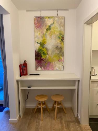 a desk in a room with two stools at Helle Souterrainwohnung mit Komfort in Munich