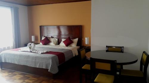 een slaapkamer met een bed met een knuffeldier erop bij Hotel Portal Colonial in San José