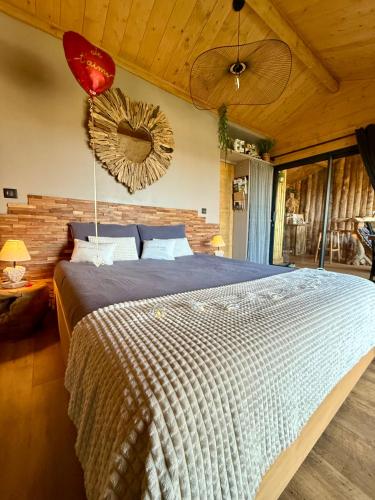 a bedroom with a large bed and a mirror at Coeur de Lodge spa privatif in Cramoisy