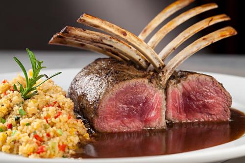 a piece of meat with a fork on a plate with food at Venit Mio Hotel in Rio de Janeiro