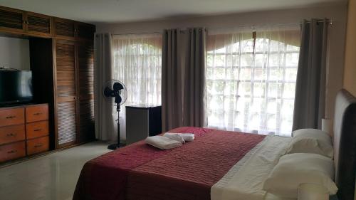 a bedroom with a bed with two towels on it at Hotel Portal Colonial in San José