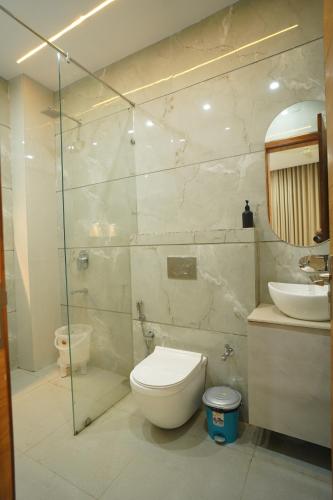 a bathroom with a toilet and a glass shower at Shri Radha Krishnam in Barsāna