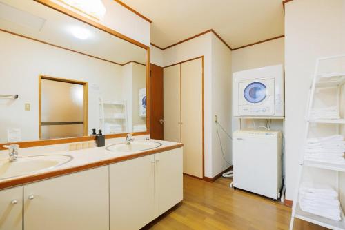 a bathroom with two sinks and a washer and dryer at 山水苑-道-温泉付き貸別荘ガイアリゾート in Zao