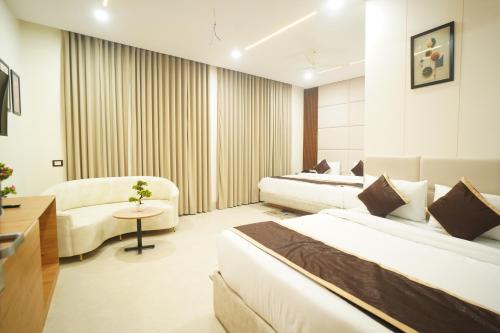 a hotel room with two beds and a couch at Shri Radha Krishnam in Barsāna