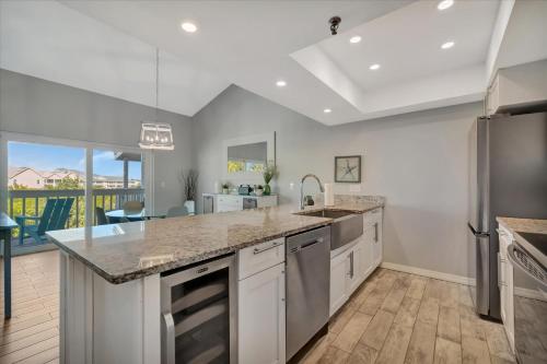 a kitchen with white cabinets and a large counter top at Beach Access & Heated Pool Resort Condo for 8 in Clearwater Beach