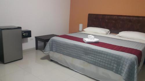 a bedroom with a bed with two towels on it at Hotel Portal Colonial in San José