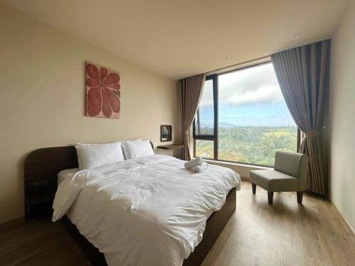 a bedroom with a bed and a chair and a large window at Le VyN Mang Den in Kon Plong