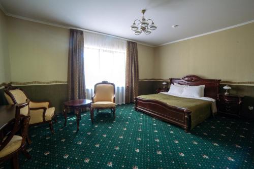 a hotel room with a bed and chairs and a window at Park Hotel Borvikha in Pilichki