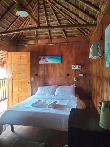 a bedroom with a white bed in a room at The Garden Tropical Cabins in Basdiot