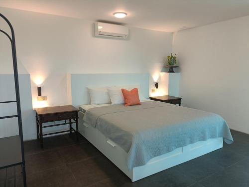 a bedroom with a bed and a nightstand with two tables at Spacious & Scenic View with Swimming Pool Aza Sunset Villa 2 in Langkawi Intl