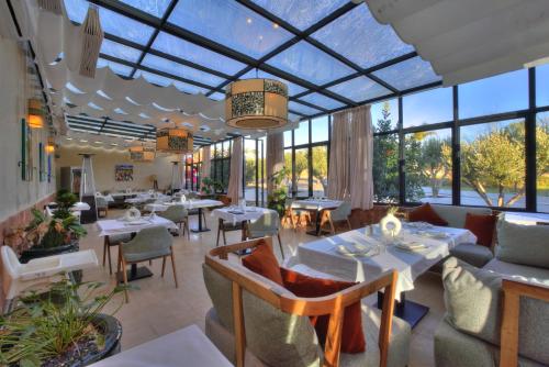 a restaurant with tables and chairs and large windows at The Ranch Camp in El Karia