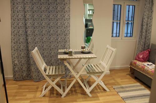 een eettafel met 2 stoelen en een spiegel bij Apartamento Sapato in Lissabon