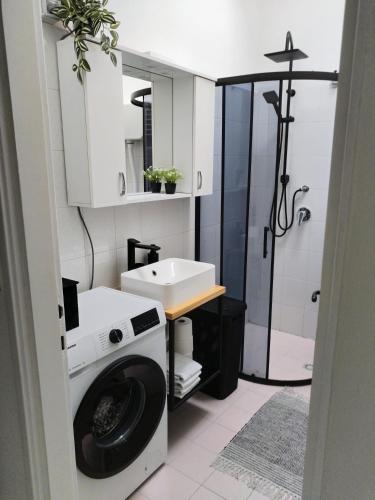 a bathroom with a washing machine and a sink at Appartameno Calnova in Vodnjan