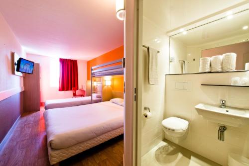 Habitación de hotel con cama y lavabo en Premiere Classe Sens Nord- Saint Clément en Sens