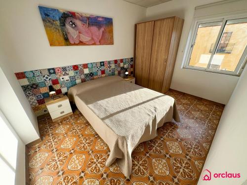 a small bedroom with a bed and a window at El Mini Piso in San Juan de Moró