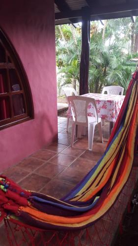 a hammock on a patio with a table and chairs at Hotel El Paraiso Escondido - Costa Rica in Jacó