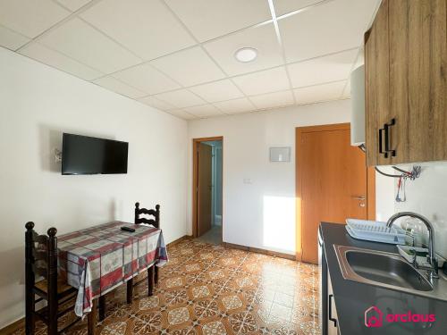 a kitchen with a sink and a table in a room at El Mini Piso in San Juan de Moró