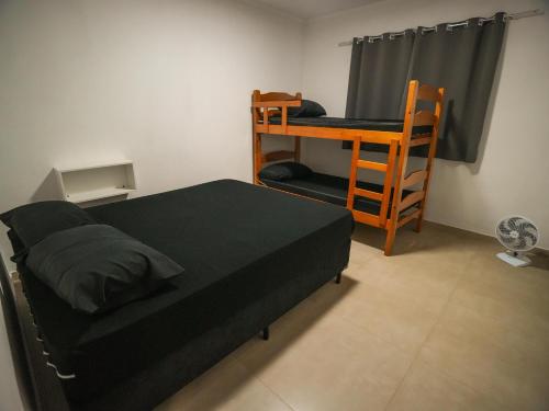 a bedroom with a bed and a desk and a chair at Recanto do entardecer in Socorro