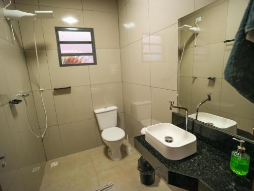 a bathroom with a toilet and a sink and a shower at Recanto do entardecer in Socorro