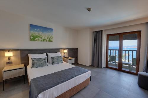 a hotel room with a bed and a balcony at Diamond Of Bodrum in Bodrum City