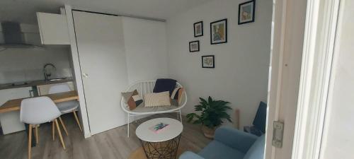 een kleine woonkamer met een tafel en stoelen bij Studio cosy in Écouflant