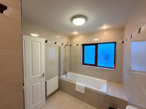 a bathroom with a bath tub and a window at Cois Cairn in Dingle
