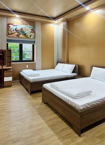 a room with two beds and a television in it at Hotel Cốc Cốc 2 in Ấp Rạch Mẹo