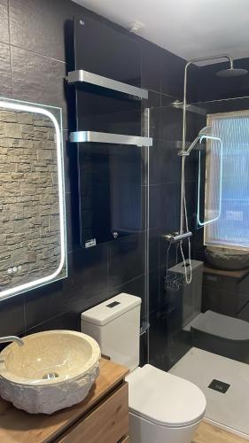 a bathroom with a sink and a toilet and a shower at Chalet de lujo con piscina cercano a la playa in Nigrán